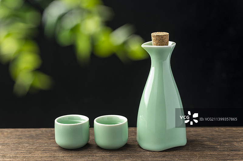 一壶酒酒壶酒杯摆放在木桌面上特写图片素材