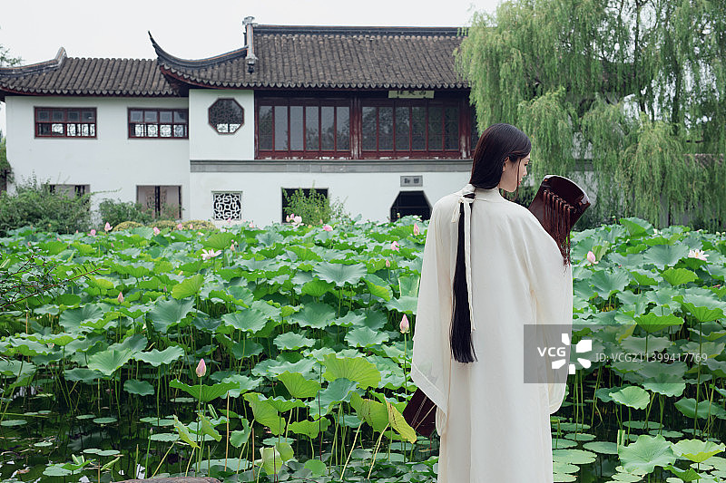 古装长发美女抱着古琴站在荷塘边图片素材