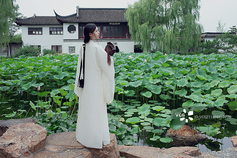 古装长发美女抱着古琴站在荷塘边图片素材
