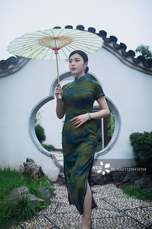 东方旗袍美女在中式园林的雨中行走图片素材
