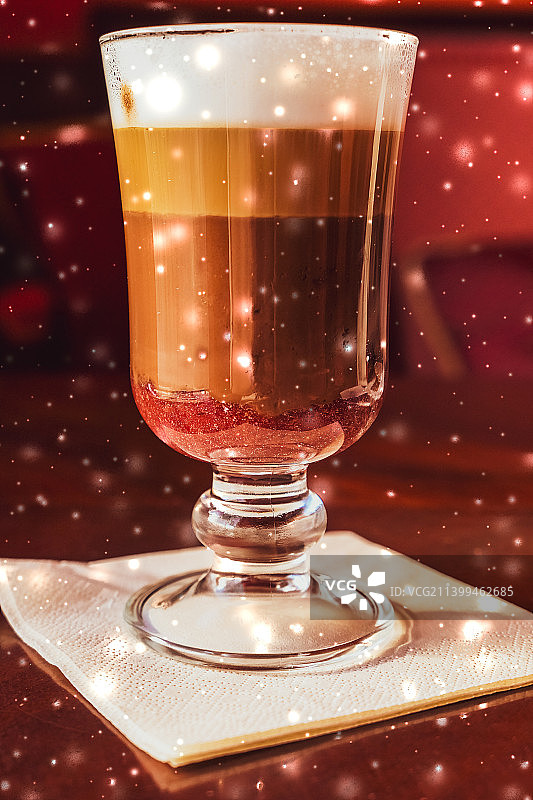 冬季假日拿铁咖啡玻璃杯和餐厅里发光的雪图片素材