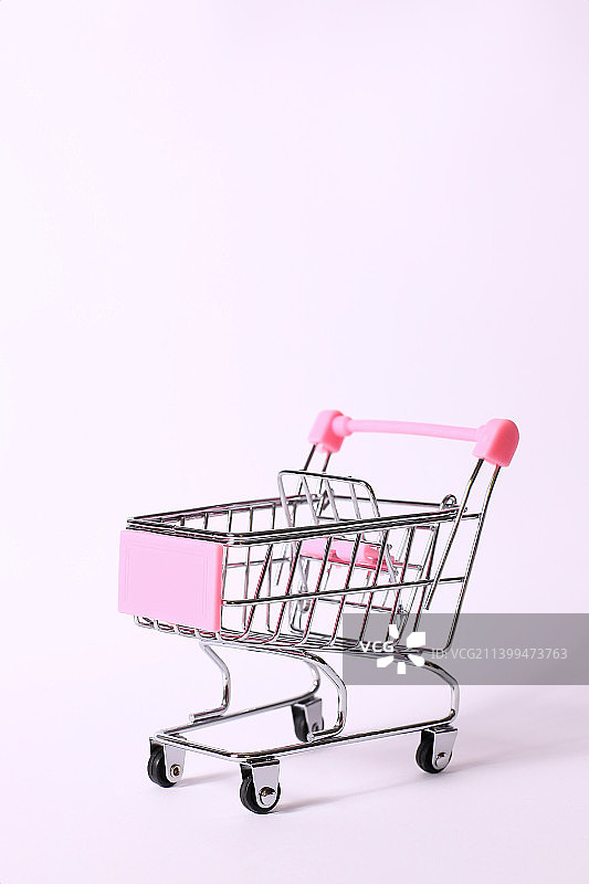 粉色背景下的购物车特写图片素材