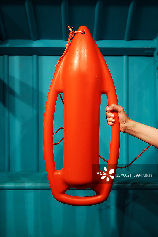 女子手持橙色救生设备特写图片素材
