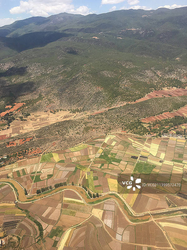 航拍云南丽江群山下的彩色农田图片素材