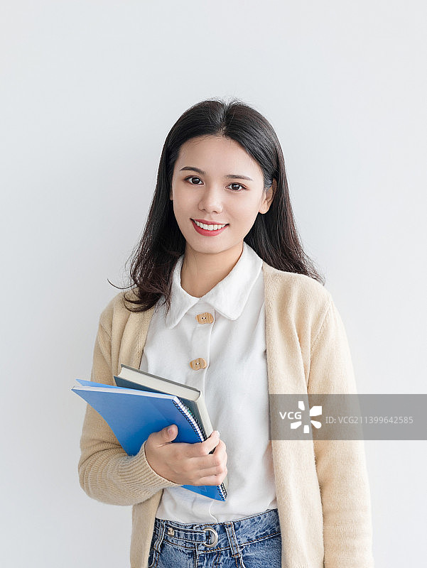 一名手拿着书本的年轻女性美女大学生图片素材