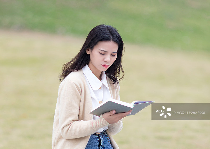 在户外认真看书的东方美女图片素材