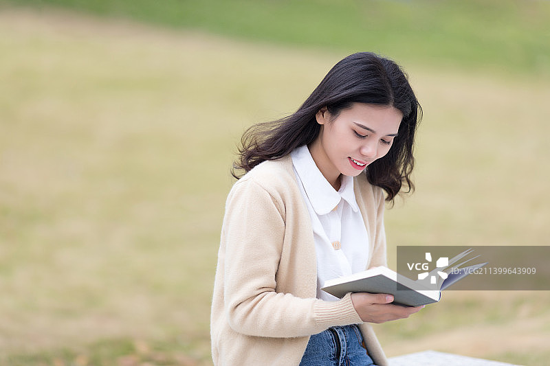 在户外认真看书的东方美女图片素材