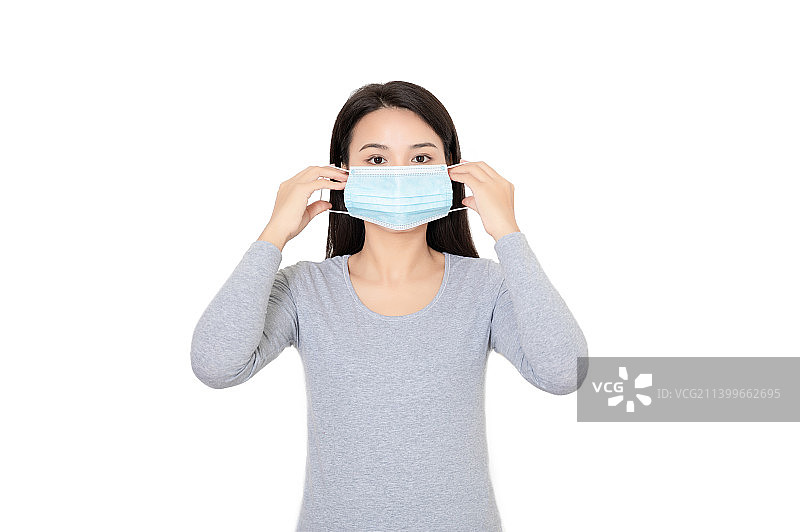 白色背景前一个戴口罩的年轻女性图片素材