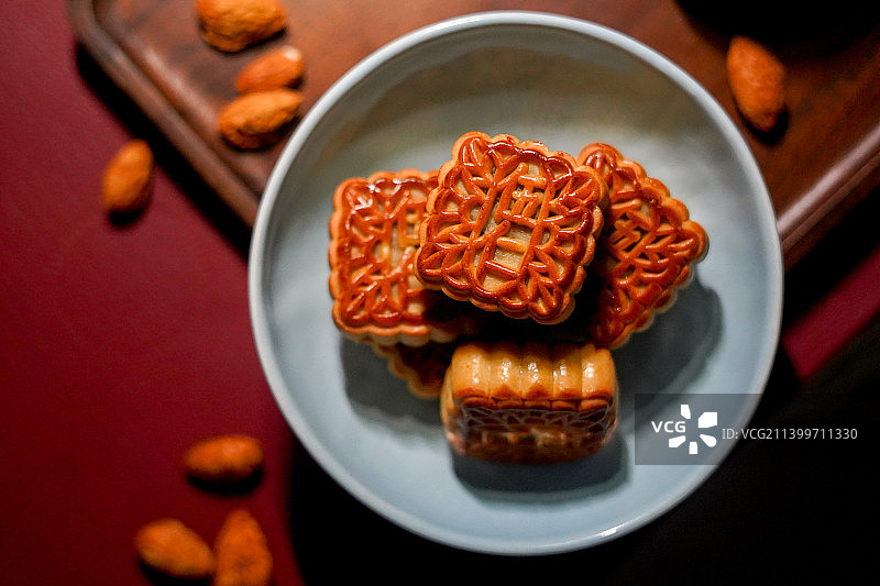 中秋节红色背景青色盘里的伍仁月饼图片素材