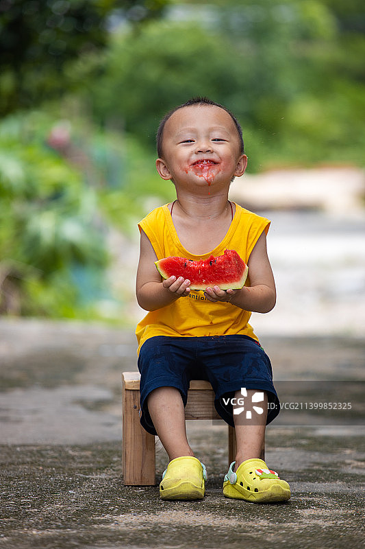 夏天小男孩巷口吃西瓜图片素材