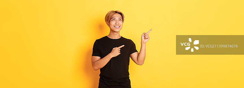 指向左上方的帅气韩国金发男子肖像图片素材