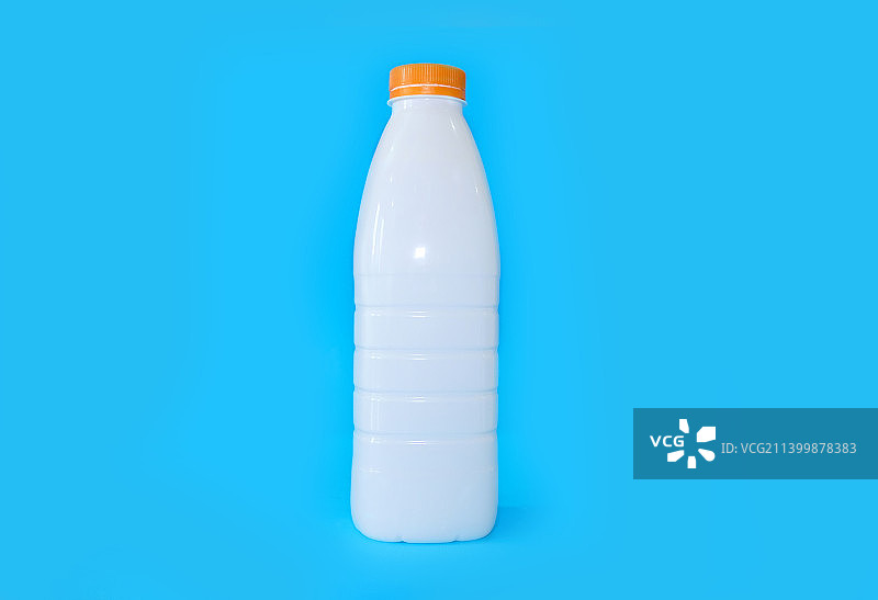 亮蓝色背景上的牛奶瓶图片素材