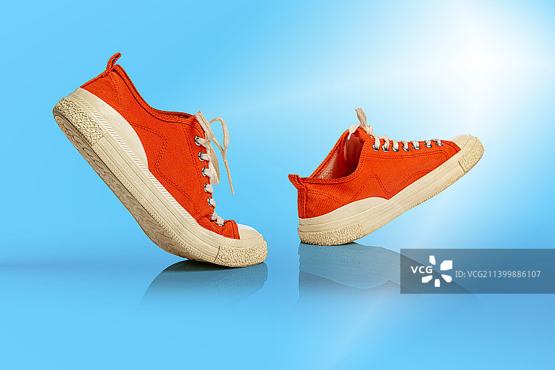 蓝色背景上的白色橙色运动鞋图片素材