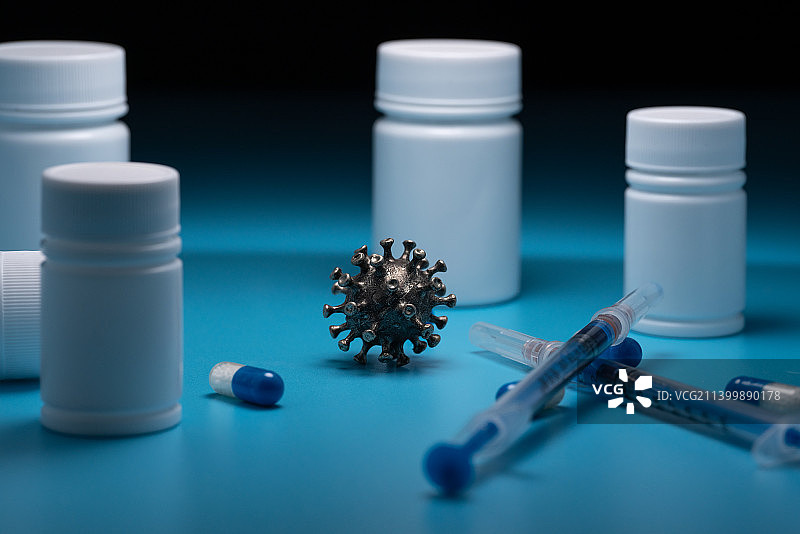 新冠病毒模型和药瓶药丸和针管静物图图片素材
