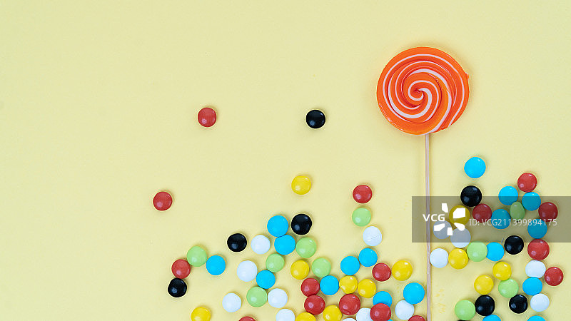 鲜艳彩色背景上的糖果：棒棒糖和彩色糖果图片素材