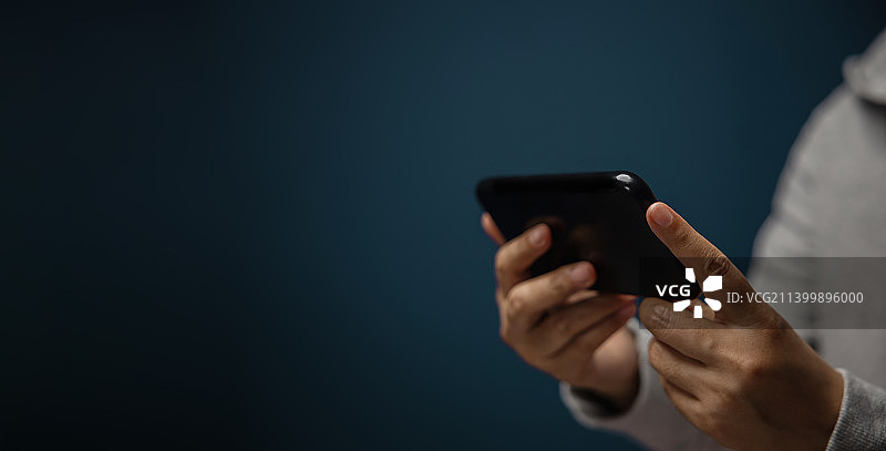 使用手机的手部特写，拍摄于泰国图片素材