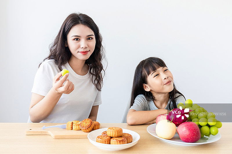 妈妈和女儿在家吃中秋节美食图片素材