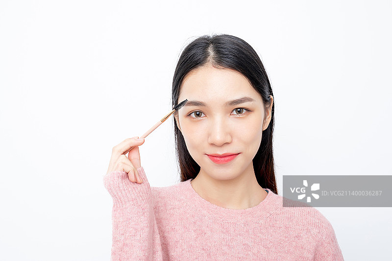 白色背景中一名年轻女性在化妆图片素材