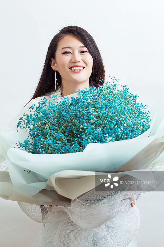 抱着蓝色满天星花束的漂亮女生图片素材