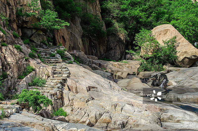中国自然风光拍摄主题，山东省泰安市岱岳区彩石溪风景区，绿色的山区树林和河道里的台架，户外白昼无人图像图片素材