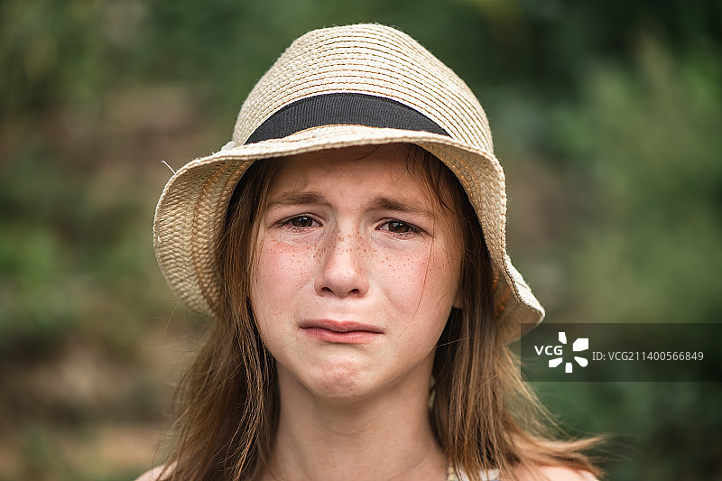 戴着帽子的可爱女孩在悲伤地哭泣图片素材