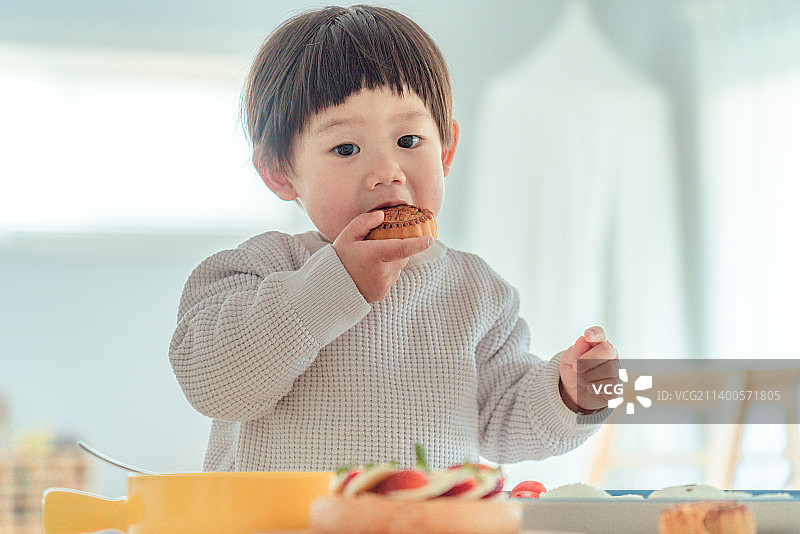 可爱小男孩享受中秋节日美食图片素材