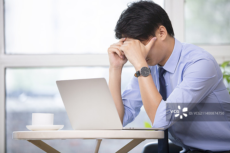 商务男士在咖啡厅使用笔记本电脑工作图片素材