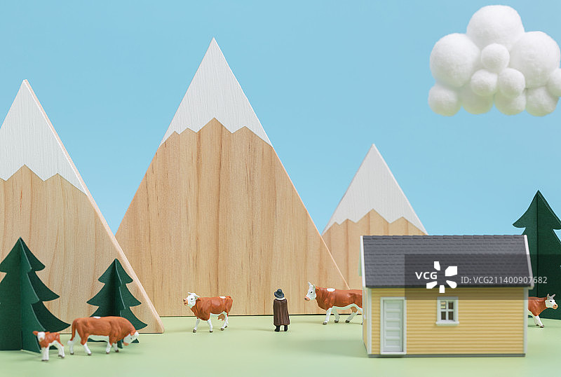 微缩创意雪山小屋牧场旁的奶牛与放牧人图片素材