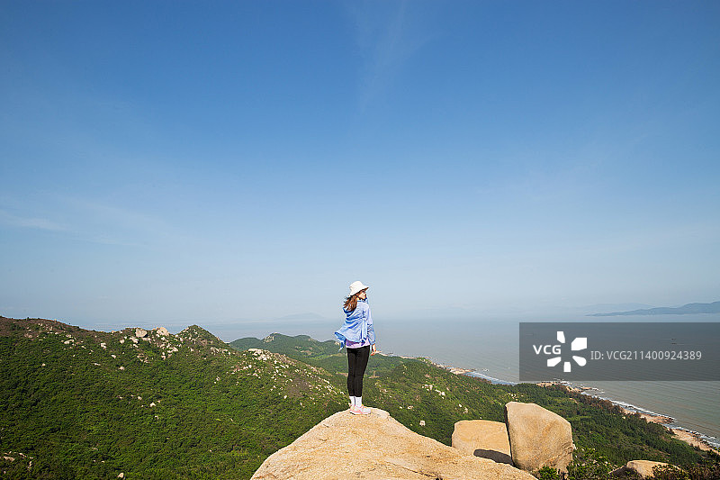 户外徒步爬山面朝大海的女生图片素材