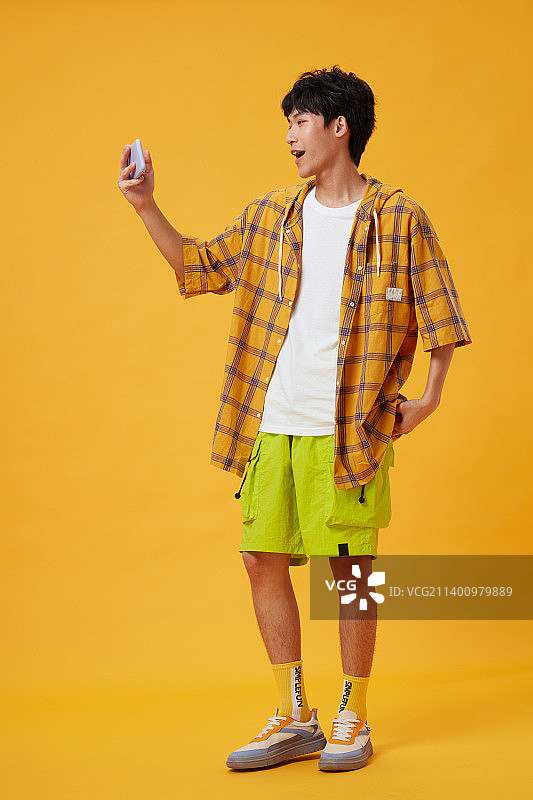 手拿手机的年轻男孩图片素材