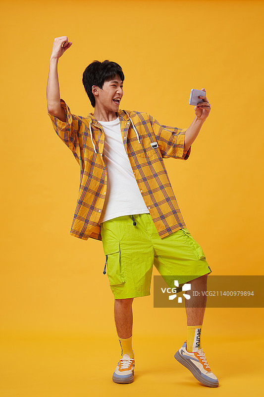 手拿手机的年轻男孩图片素材