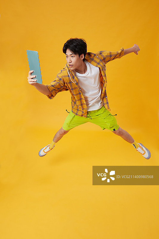 手拿平板电脑的年轻男孩图片素材