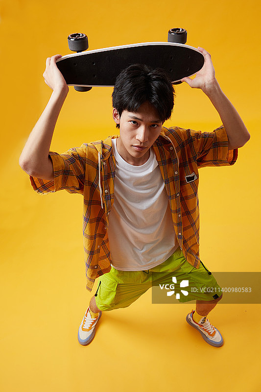 手拉滑板的年轻男孩图片素材