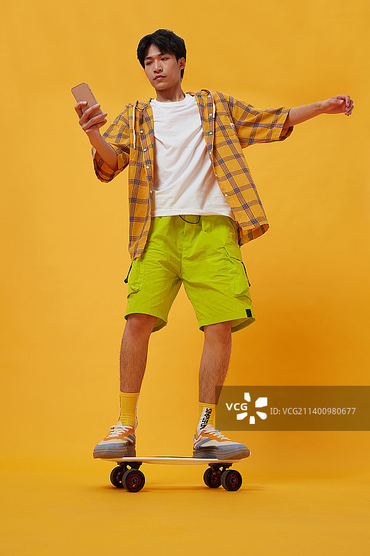 坐在滑板上的年轻男孩图片素材