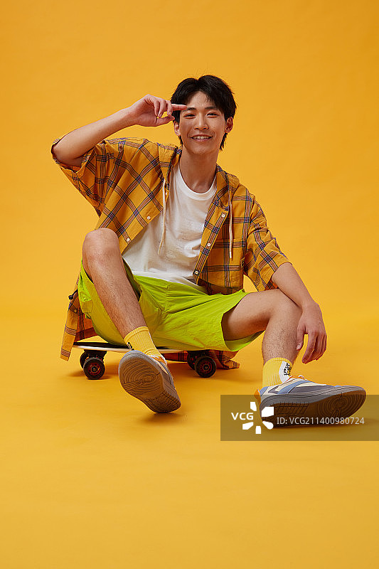 坐在滑板上的年轻男孩图片素材