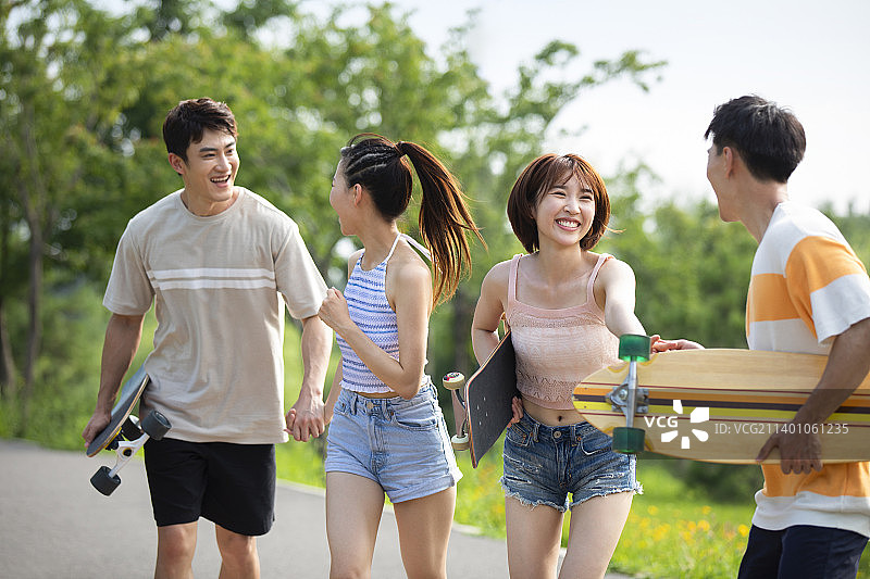 快乐的年轻人在公园玩滑板图片素材