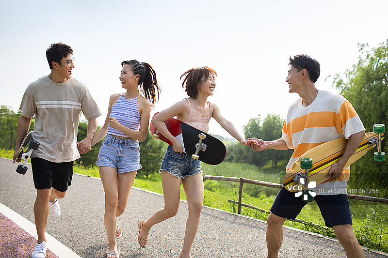 快乐的年轻人在公园玩滑板图片素材