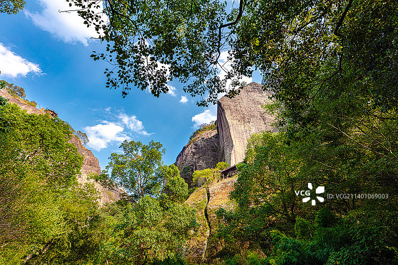 福建武夷山天游峰低视角仰视，刀切般平整的壁立万仞绝壁，一条裂缝从巨大的丹霞地貌山岩中穿过图片素材