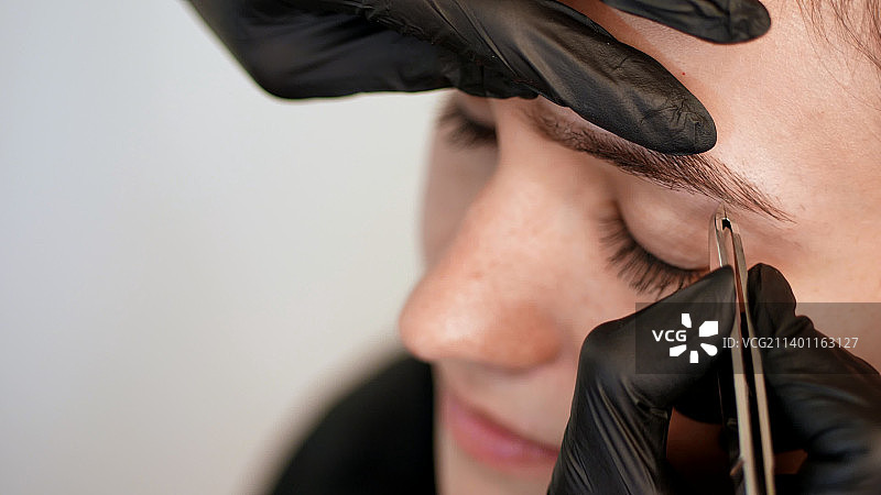 美容院特写：美容师戴黑色橡胶手套的手图片素材