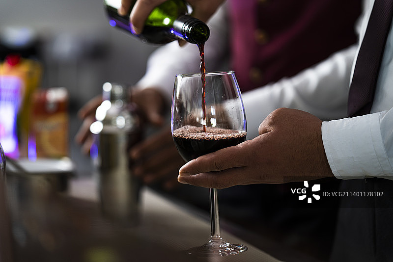 男人往玻璃杯里倒酒的腹部特写图片素材