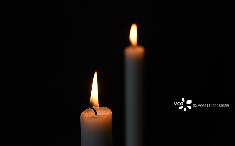 黑色背景中点燃的蜡烛特写图片素材