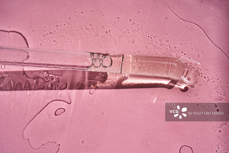 粉色背景上的精华或化妆油滴管图片素材