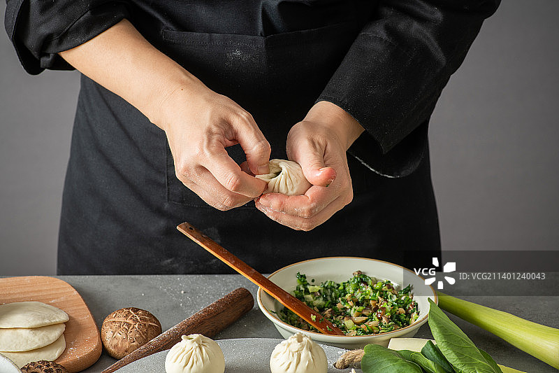 专业面点师傅在制作香菇青菜包子，菜包图片素材