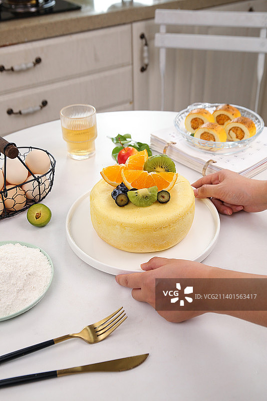 手端着一盘水果蛋糕图片素材