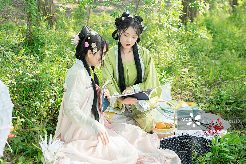 两个汉服美女在树林里学习玩乐图片素材