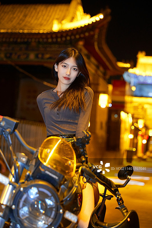 夜晚古城景区骑摩托的少女图片素材