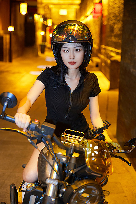 夜晚古城景区骑摩托的少女图片素材