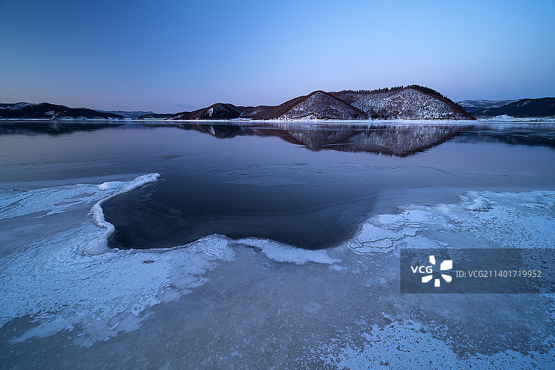 日落后的冰湖和绵延起伏的山脉图片素材