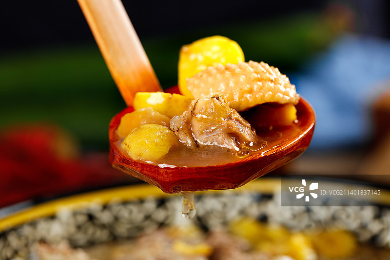 勺子里舀着板栗炖鸡图片素材