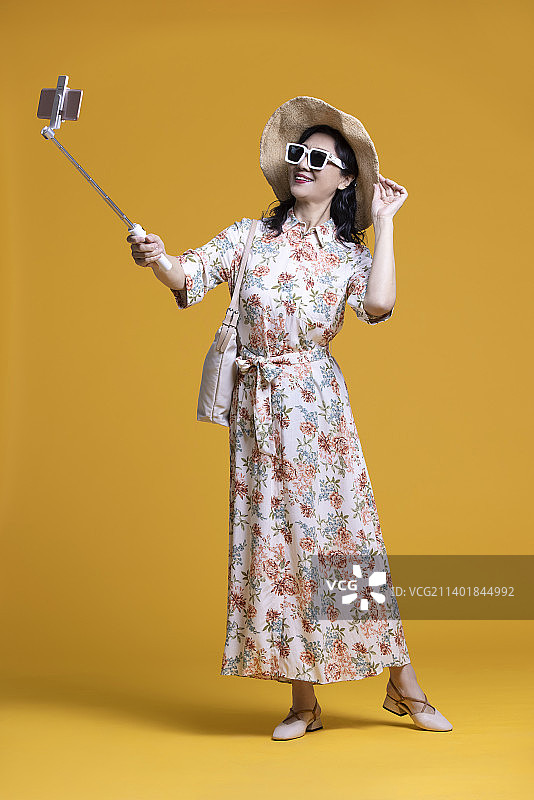 快乐的老年女子用手机自拍图片素材